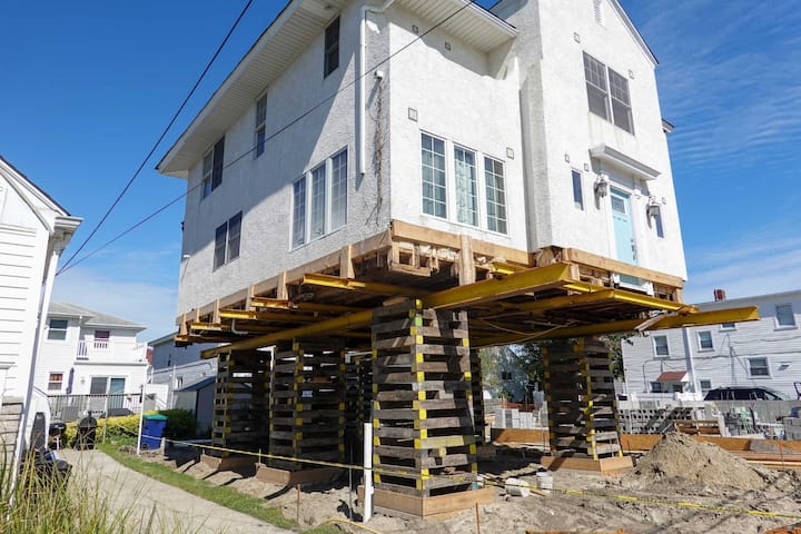 A team of professionals using specialized equipment to raise a house in Covington, preparing it for elevation and renovation